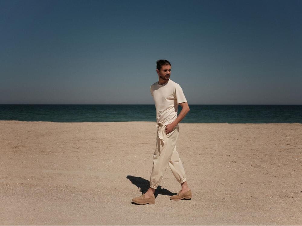 barbat in fata marii imbracat in alb cu pantofi maro